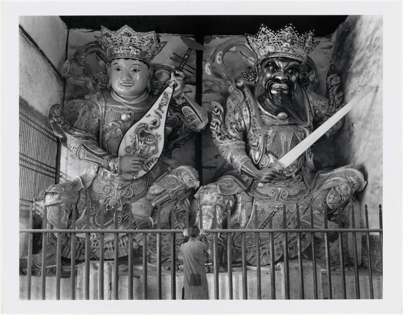 A Buddhist Monk Stands Before Two Giant Guardian Gods in the Entrance Hall of the Hsi Shan Temple
