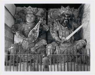 A Buddhist Monk Stands Before Two Giant Guardian Gods in the Entrance Hall of the Hsi Shan Temple