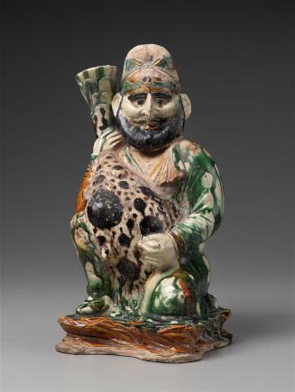 A Man of West Asian type holding a leopard skin-covered bottle