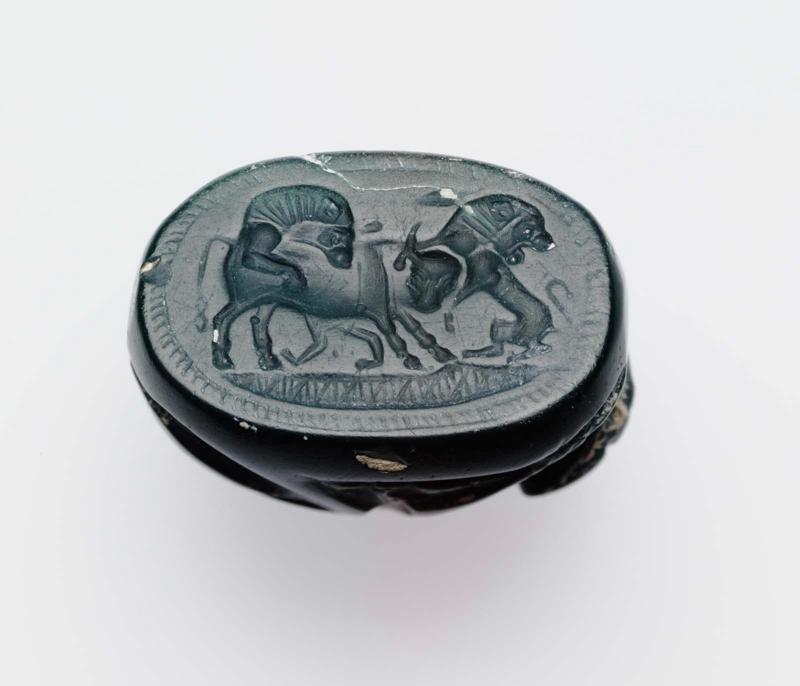 Scarab with two lions attacking a bull