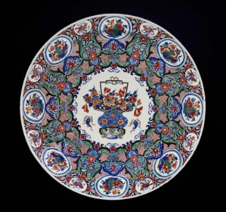 One of a pair of chargers with basket of flowers