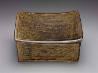 Pillow decorated with dark green glaze over carved and incised ground