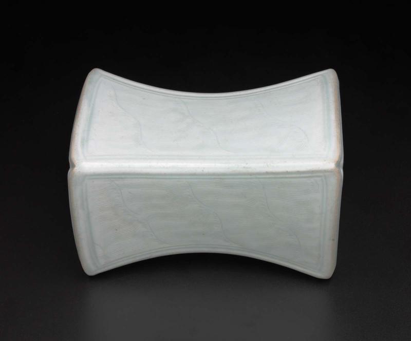 Square hourglass-shaped pillow with combed wave design