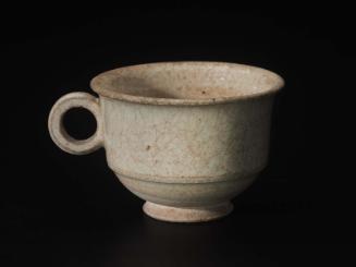 Small handled cup decorated with white glaze