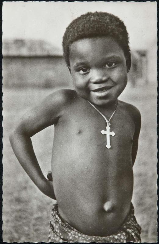 Young shirtless boy with a cross necklace.