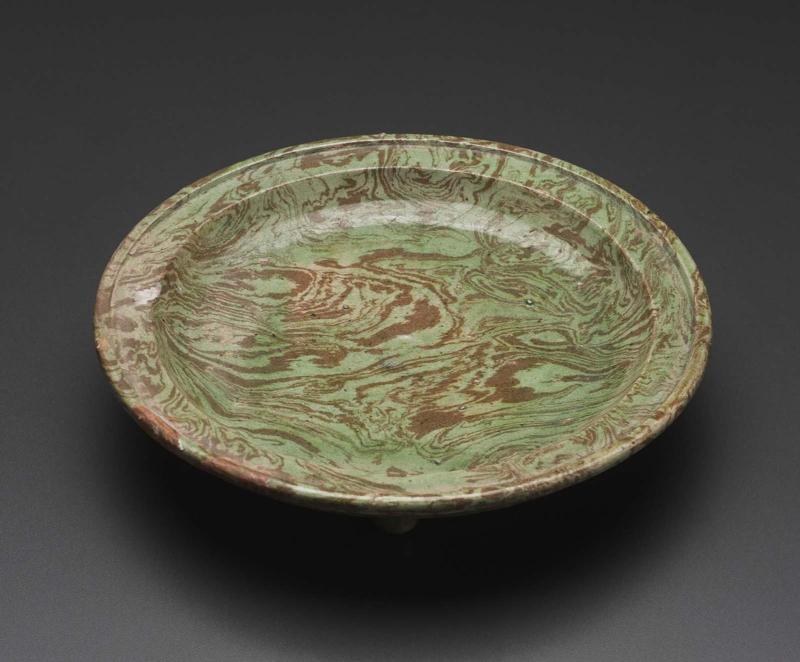 Marbleized plate on three feet decorated with transparent green glaze
