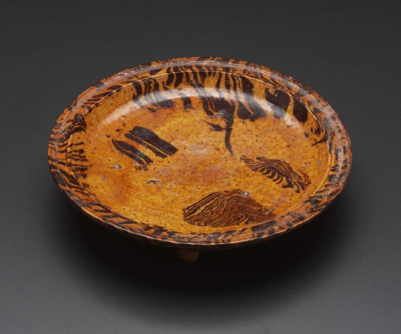 Marbleized plate on three feet decorated with transparent yellow glaze