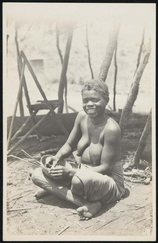 Smiling woman sitting down and weaving a basket