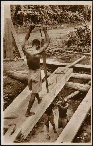 Construction workers using a large saw.