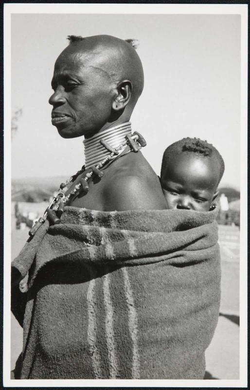 Woman in profile, carring her baby.