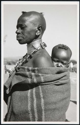 Woman in profile, carring her baby.
