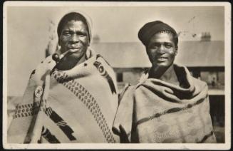 Two men, one smoking a pipe.