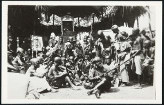 AFRICA - Guardsmen of the tribes relax while entertainment is presented, the guns are just for show, no hostility is expected.