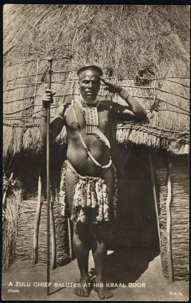 A ZULU CHIEF SALUTES AT HIS KRAAL DOOR