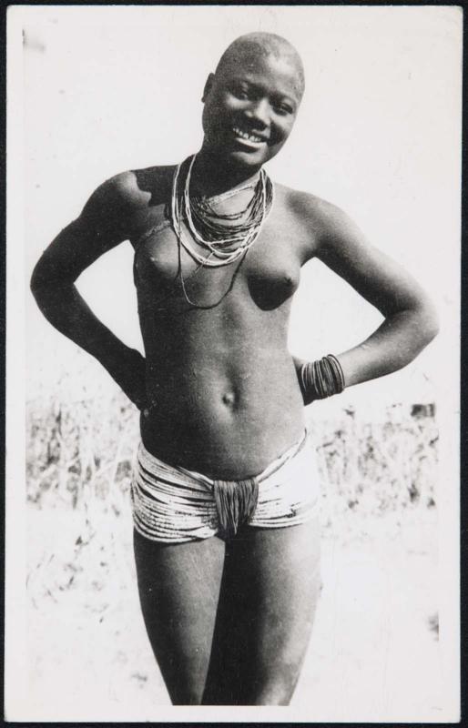 Three-quarter-length portrait of a shirtless woman with her hands behind her back