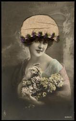 Woman holding flowers with fabric hat, and real hair.
