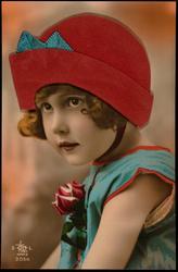 Young girl in blue jumper with red fabric hat.

