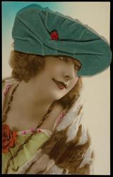 Woman in fur stole with green fabric hat and ladybug.
