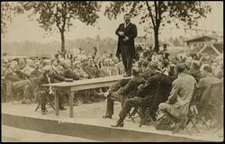 President Roosevelt orating from a table top outdoors.
