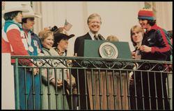 President Jimmy Carter hails the USA Olympic Hockey Team at the White House following their victory over the Soviet team during the 1980 Winter Olympics.