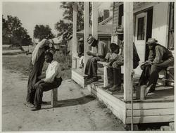 Negroes cut each others hair in front of plantation store after being paid off on Saturday, Mileston Plantation, Mississippi Delta, Mississippi, November 1939