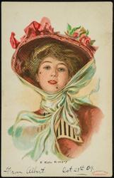 Woman in pink, netted hat and white scarf.