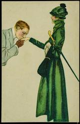 Man kissing the hand of a woman dressed in green.