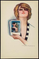 Woman looking at photos of a couple in a romantic embrace.
