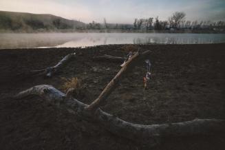 Prayer ties at the Cannonball River's edge in the morning mist