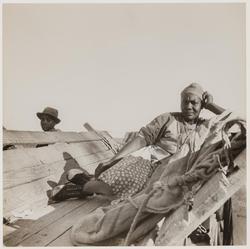 Untitled (woman reclining on wooden bench)