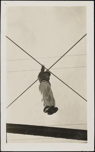 Man hanging from crossed wires