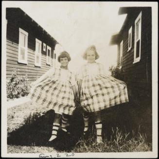 Two girls in plaid dresses