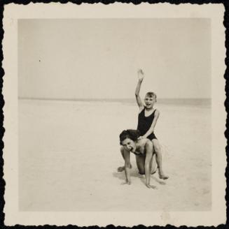 Boy on woman's back at the beach