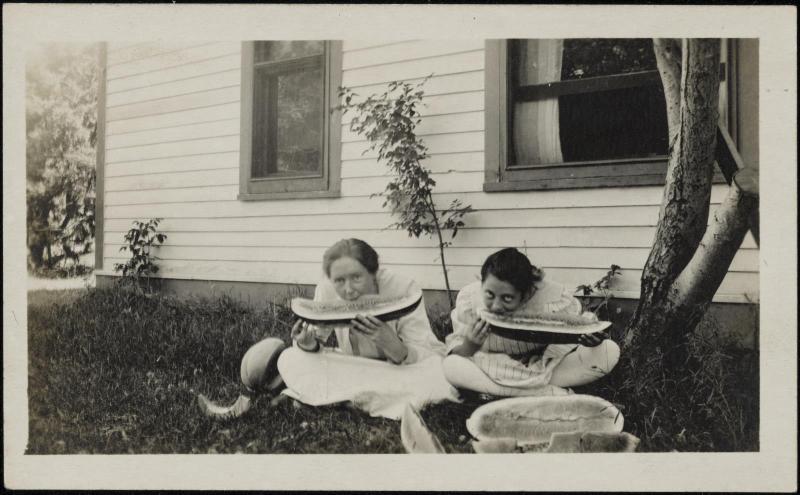 Women eating watermelon in yard