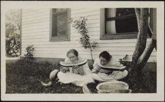 Women eating watermelon in yard