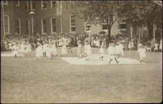Large group of children around maypole 
