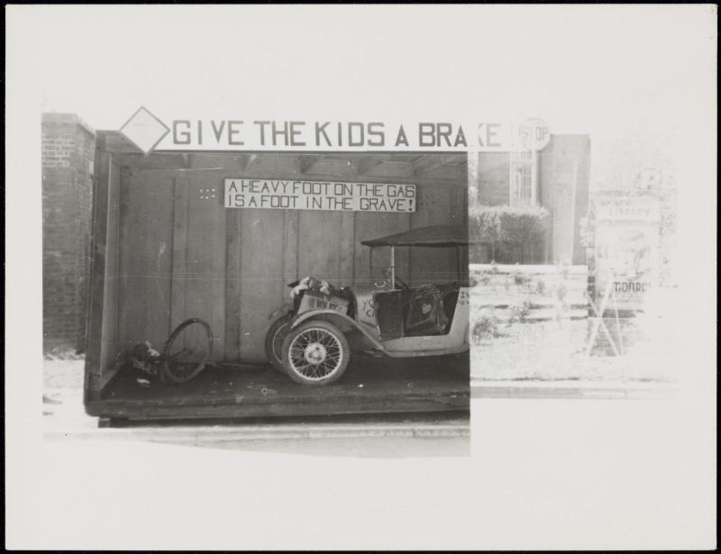 Automobile under "Give the Kids a Brake" sign