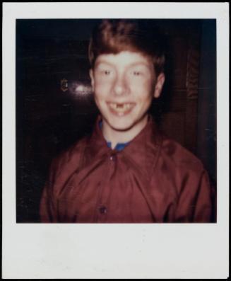 Grinning red-headed boy with missing tooth