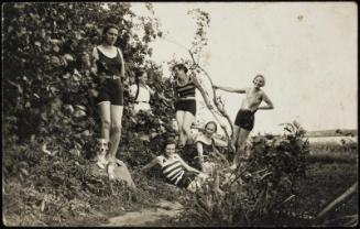 Six women in bathing suits and a dog in the countryside