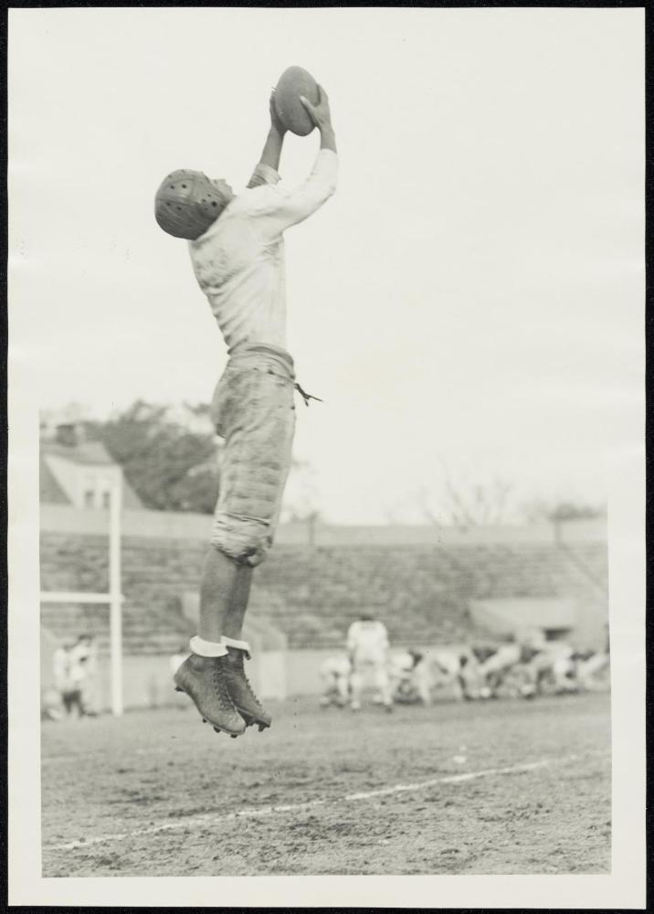 Young man jumping to catch football