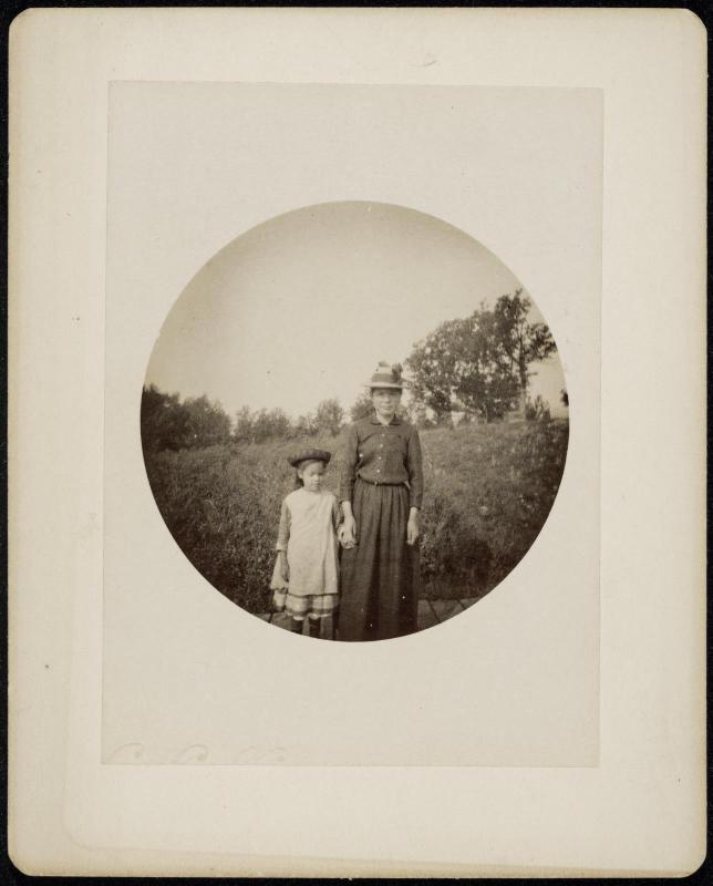 Circular Kodak image of a woman and child standing in a field holding hands