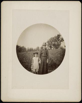 Circular Kodak image of a woman and child standing in a field holding hands