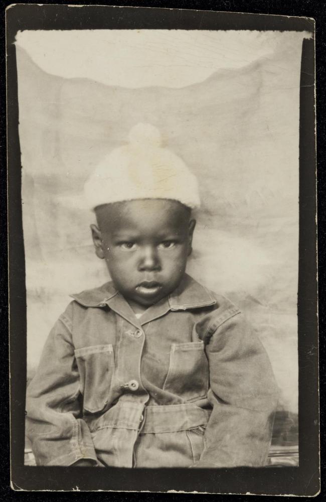 Studio portrait of a young boy in white hat with pompom