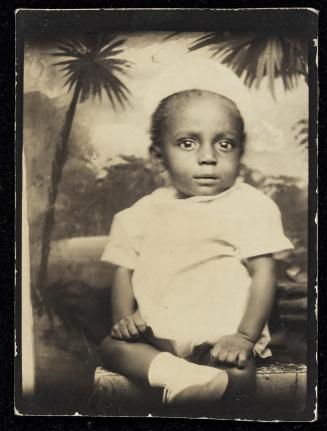 Photo booth portrait of small child with palm trees in background