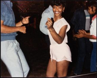 Young woman dancing and wearing short white jumpsuit