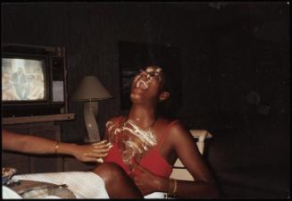 Young woman with head thrown back laughing and being smeared with a white substance