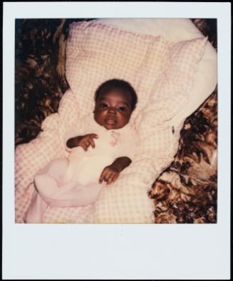 Portrait of baby in seat with checked blanket