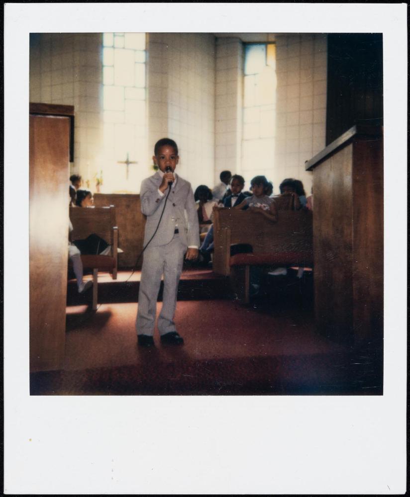 Little boy in grey suit with microphone in church