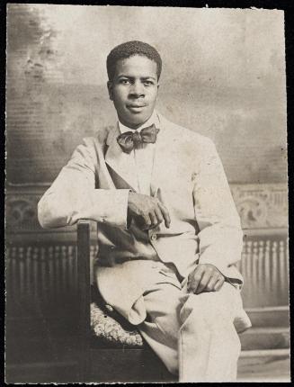 Studio portrait of a seated man with bow tie