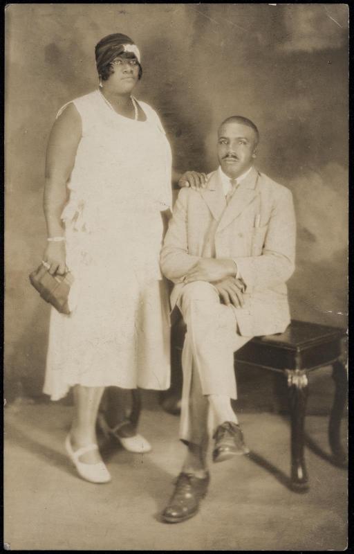 Studio portrait of a couple with woman standing and man seated